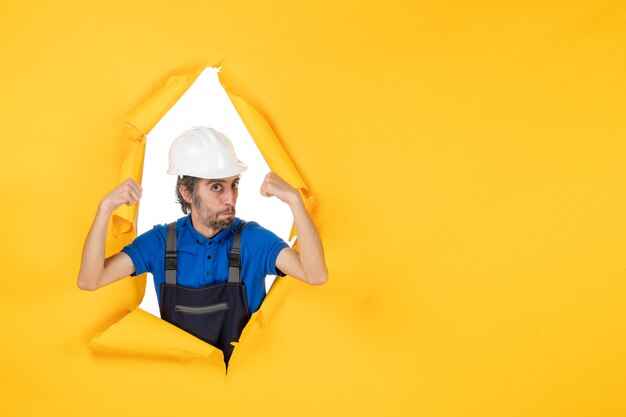 Vorderansicht männlicher Baumeister in Uniform auf gelbem Hintergrund