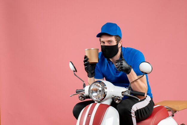 Vorderansicht männlicher Kurier, der auf dem Fahrrad sitzt und eine große Kaffeetasse auf dem Rosa hält