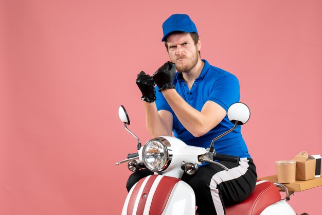 Vorderansicht männlicher Kurier in blauer Uniform auf rosa Lebensmittelfahrrad-Lieferjob Farbarbeitsservice Fast-Food fast