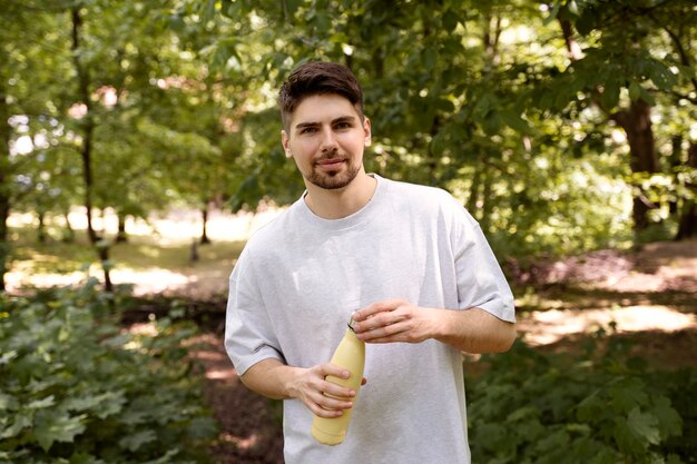 Vorderansicht Mann, der Wasserflasche hält