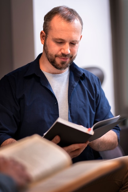 Kostenloses Foto vorderansicht mann liest im buchclub