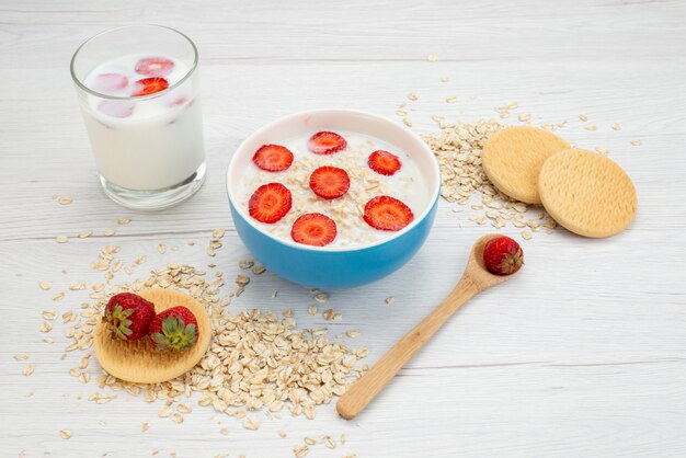 Vorderansicht Milch mit Haferflocken Innenplatte mit Erdbeeren zusammen mit Glas Milch auf weiße Milch Milch Frühstück Gesundheit