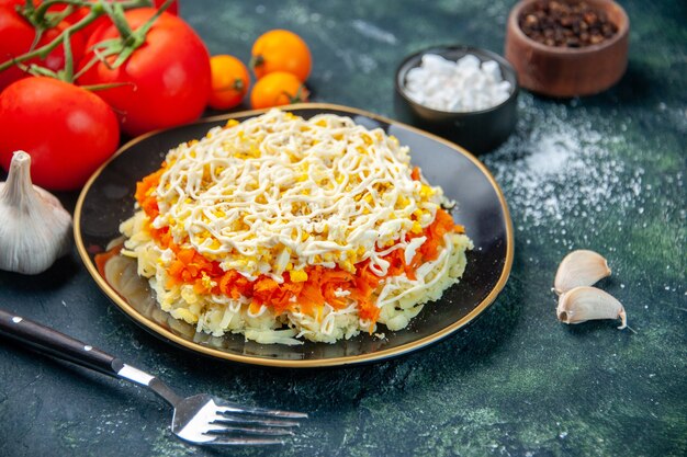 Vorderansicht Mimosensalat innerhalb Platte mit Gewürzen und Tomaten auf dunkelblauer Oberfläche Fotoküche Urlaub Geburtstag Mahlzeit Küche Farbe Essen