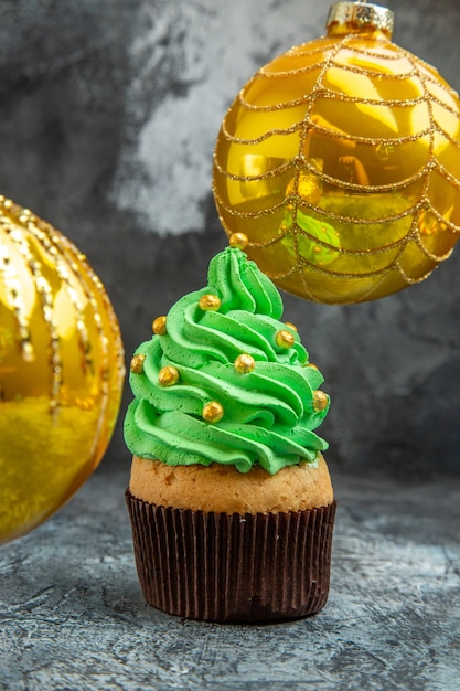Vorderansicht Mini bunte Cupcakes gelbes Weihnachtsbaumspielzeug auf Dunkelheit