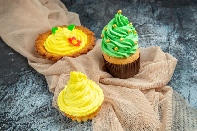 Vorderansicht Mini bunte Cupcakes Keks beige Schal auf dunklem Hintergrund