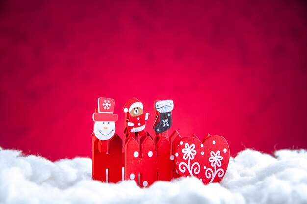 Vorderansicht Mini-Weihnachtsspielzeug auf rotem Hintergrund