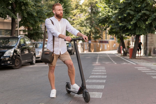 Vorderansicht moderner Mann auf Roller im Freien