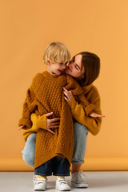 Kostenloses Foto vorderansicht-mutter, die smiley-kind hält