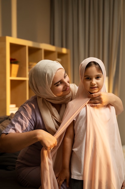 Kostenloses Foto vorderansicht mutter hilft mädchen mit hijab