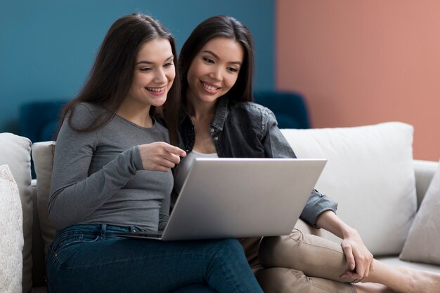 Vorderansicht niedliche junge Frauen, die den Laptop überprüfen