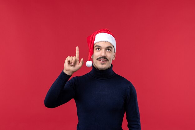 Vorderansicht normaler Mann mit roter Feiertagskappe auf rotem Hintergrund