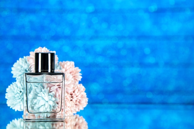 Kostenloses Foto vorderansicht parfümflasche blumen auf blauem hintergrund mit freiem platz