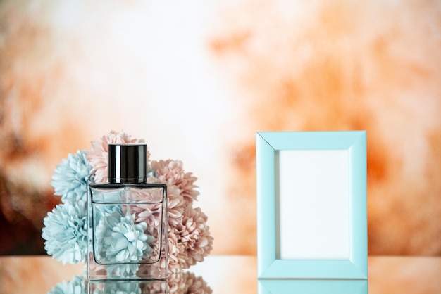 Vorderansicht Parfümflasche kleine blaue Bilderrahmen Blumen isoliert auf beigem Hintergrund