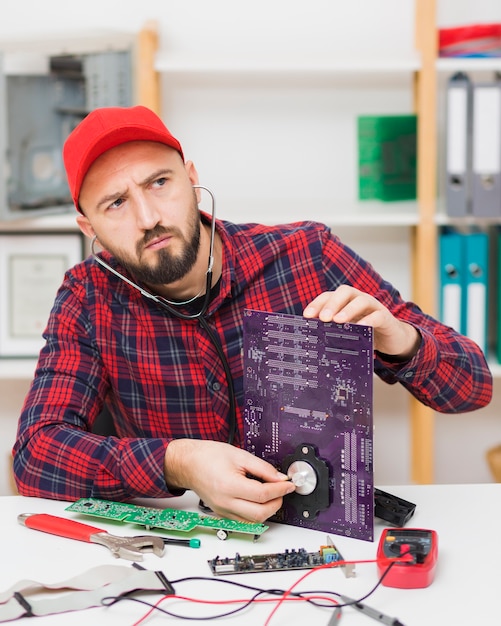 Kostenloses Foto vorderansicht person, die ein motherboard repariert
