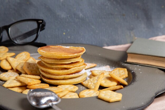 Vorderansicht Pfannkuchen mit Crackern Innenplatte mit Sonnenbrille auf grau