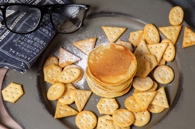 Vorderansicht Pfannkuchen und Cracker mit Sonnenbrille auf Teller