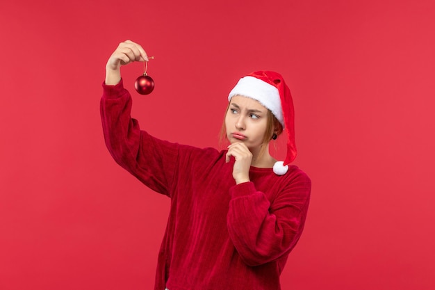 Kostenloses Foto vorderansicht regelmäßige weibliche holding weihnachtsspielzeug, roter weihnachtsfeiertag