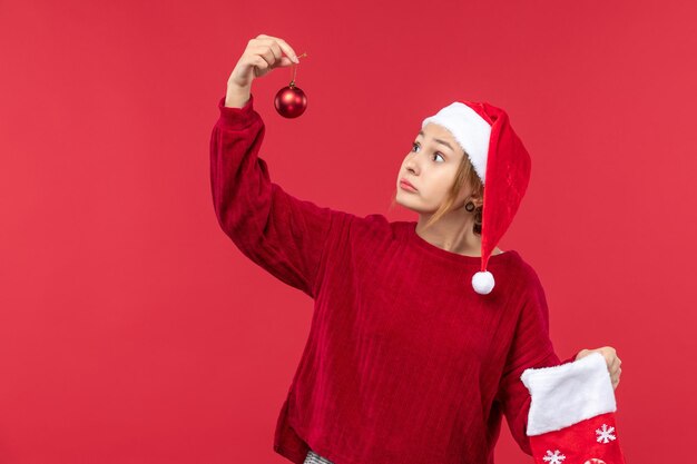 Vorderansicht regelmäßige weibliche Holding Weihnachtsspielzeug, roter Weihnachtsfeiertag