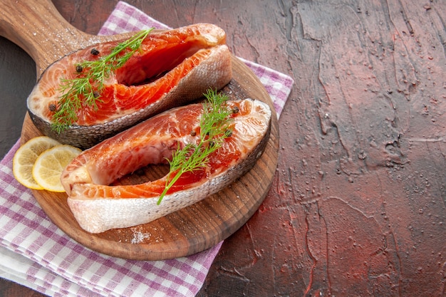 Vorderansicht rohe Fischscheiben auf dunkelrotem Fleisch Farbfoto Mahlzeit Essen Meeresfrüchte Gericht Grill