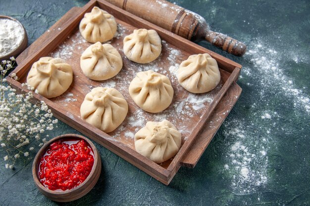 Vorderansicht rohe Knödel mit Fleisch innen auf dunkler Oberfläche Mahlzeit Farbe Mehl Gericht Teig Fleisch kochen