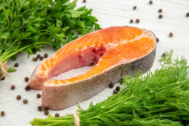 Kostenloses Foto vorderansicht rohes fleischscheibe mit grüns auf weißem hintergrundlebensmitteltierrippengerichtmehlfisch meal