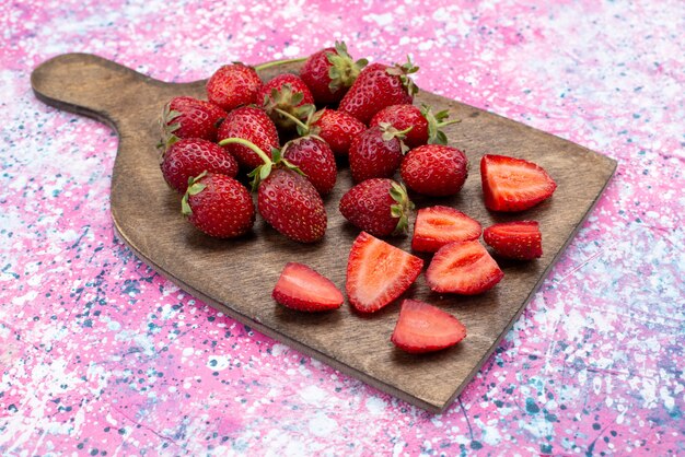 Vorderansicht rote Erdbeeren geschnitten und ganz auf Holz