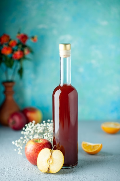 Vorderansicht roter apfelessig auf blauem wandnahrungsmittelgetränkfruchtalkoholwein saurer farbsaft