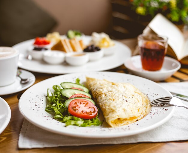 Vorderansicht Rührei mit Tomatenscheiben und Gurken mit Kräutern auf einem Teller