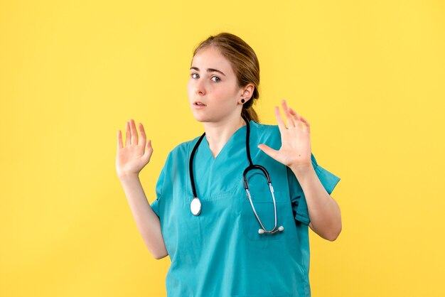 Vorderansicht Ärztin auf gelbem Hintergrund Emotionen Krankenhausgesundheitsmediziner