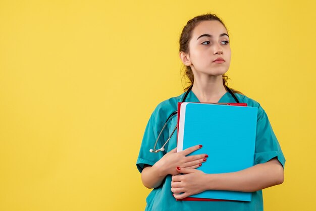 Vorderansicht Ärztin im medizinischen Hemd, das Notizen hält, Farbvirus-Gesundheitsgefühle covid-19-Pandemieuniform