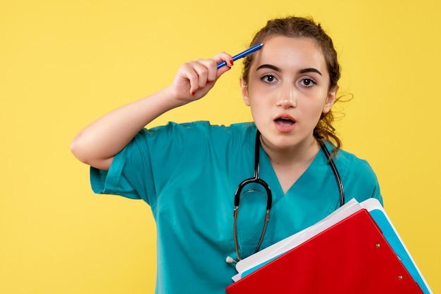 Vorderansicht Ärztin im medizinischen Hemd, das verschiedene Notizen hält, Farbe Pandemievirus-Gesundheitsgefühle covid-19 Uniform