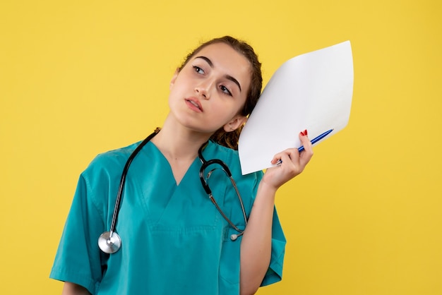 Vorderansicht Ärztin im medizinischen Hemd mit Papieren und Stethoskop, Emotion Uniform Pandemie Gesundheit Covid-19-Virus
