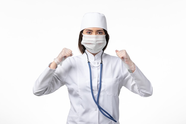 Vorderansicht Ärztin im weißen sterilen medizinischen Anzug mit Maske aufgrund von Coronavirus auf Weißwandkrankheit Krankheit Pandemie-Covid-Virus