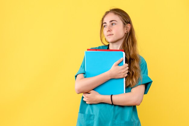 Vorderansicht Ärztin mit Analysen auf gelbem Hintergrund Krankenschwester Sanitäter Krankenhausgesundheit