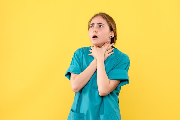 Vorderansicht Ärztin mit Atemproblemen auf gelbem Hintergrund Gesundheit Emotion Sanitäter