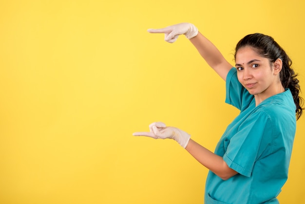 Vorderansicht Ärztin mit Latexhandschuhen, die Größe mit Händen zeigen
