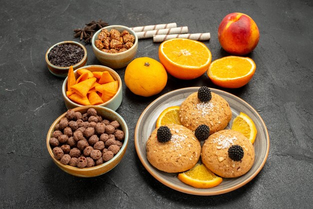 Vorderansicht Sandkekse mit Orangenscheiben auf dunkelgrauem Hintergrund süßer Fruchtkeks-Keks-Tee-Kuchen