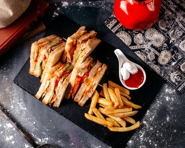 Vorderansicht Sandwich-Scheiben lecker zusammen mit Pommes Frites in schwarzen Teller auf dem grauen Boden