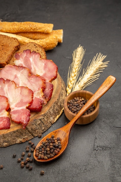 Vorderansicht Schinkenscheiben mit Brötchen und Brotscheiben auf der dunklen Farbfoto-Snack-Fleischmahlzeit