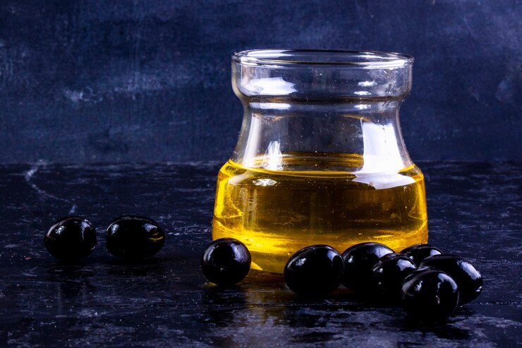 Kostenlose Foto vorderansicht schwarze oliven mit olivenöl in einem glas auf schwarz