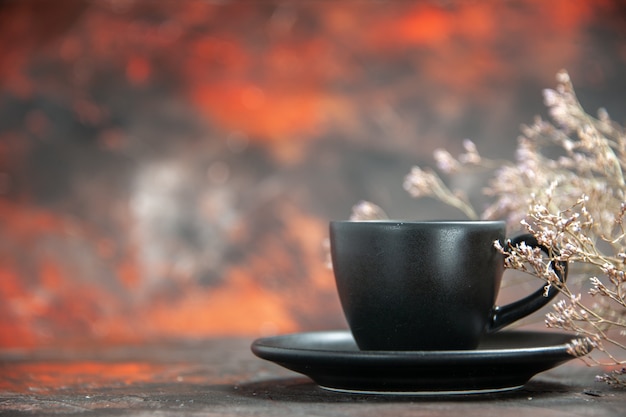 Kostenloses Foto vorderansicht schwarze tasse und untertasse auf dunkelrotem tisch mit freiem platz