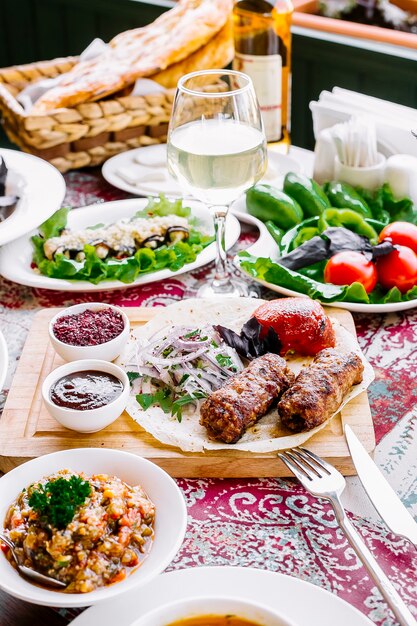 Vorderansicht serviert Tisch Lula Kebab auf Fladenbrot mit Zwiebeln und Tomaten