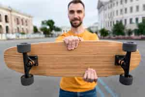 Kostenloses Foto vorderansicht skateboard und verschwommener mann