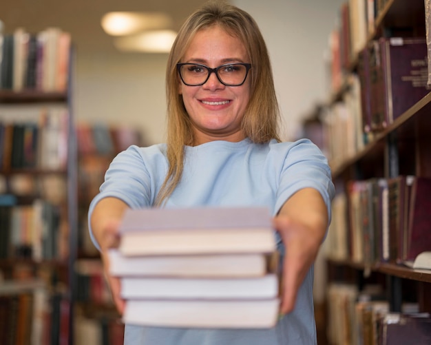 Kostenloses Foto vorderansicht-smiley-frau, die bücher hält