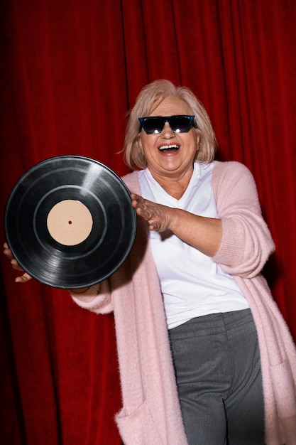 Kostenloses Foto vorderansicht-smiley-frau mit vinyl-schallplatte