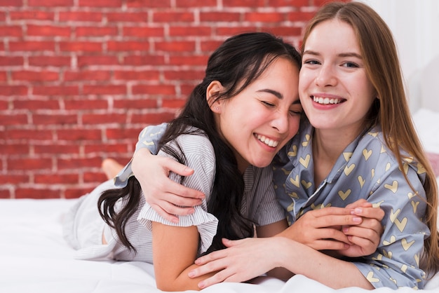 Kostenloses Foto vorderansicht smiley frauen umarmen