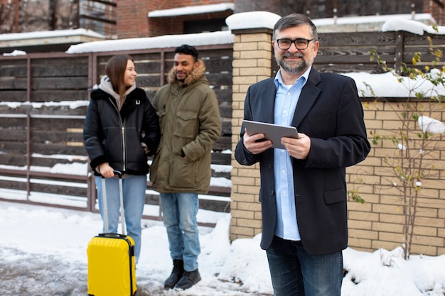 Kostenloses Foto vorderansicht-smiley-host mit tablet