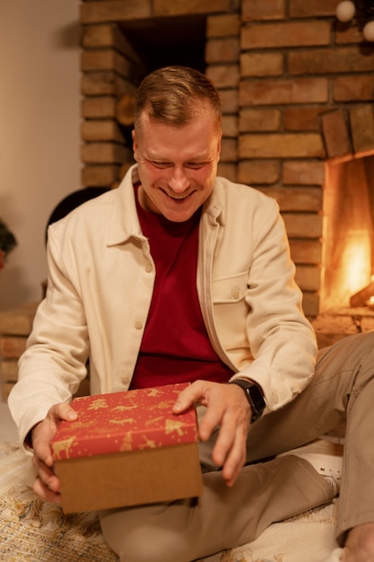 Kostenloses Foto vorderansicht-smiley-mann-öffnungsgeschenk