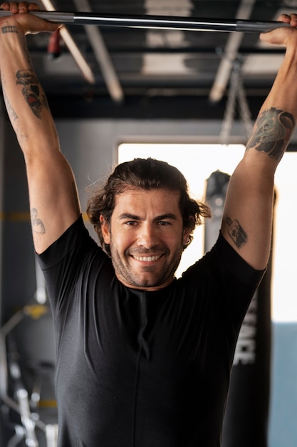 Kostenloses Foto vorderansicht-smiley-mann-training im fitnessstudio