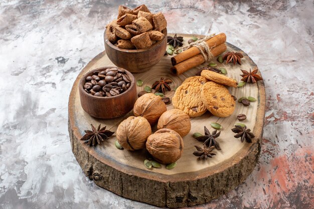 Vorderansicht süße Kekse mit Kaffee und Walnüssen auf hellem Hintergrund Zuckerteefarbe Cookie süßer Kakaokuchen